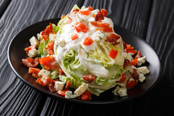 Wedge Salad with Blue Cheese, tomato and Bacon closeup on a plate. horizontal