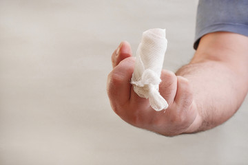 insulting gesture of injured middle finger wrapped with gauze bandage with copy space
