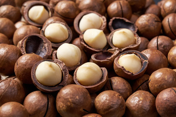 Shelled and unshelled macadamia nuts  background close-up.
