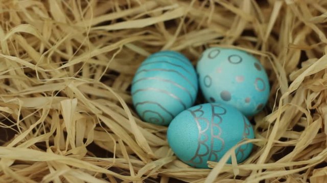 Eggs blue flowers lie on the hay. Easter holiday concept