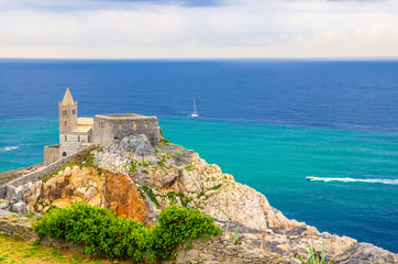 Fototapeta na wymiar Chiesa San Pietro catholic church, Lord Byron Parque Natural park De Portovenere town on stone cliff rock, yachts on turquoise water of Ligurian sea, Riviera di Levante, La Spezia, Liguria, Italy