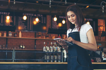 Asia Barista waiter take order from customer in coffee shop,cafe owner writing drink order