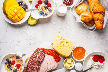 Continental breakfast table with croissants, jam, ham, cheese,  butter, granola and fruit, copy...