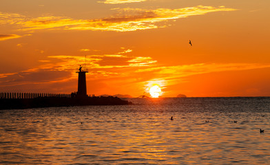 등대 사이로 떠오르는 태양