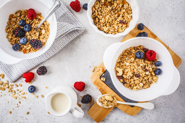 Breakfast food background. Granola with milk and berries on white table.