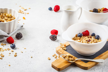 Breakfast food background. Granola with milk and berries on white table.