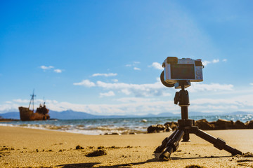 Camera on tripod and shipwreck