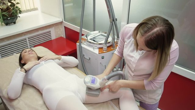 Woman having lpg massage lying on bed in spa. Clinic lipomassage in beauty salon