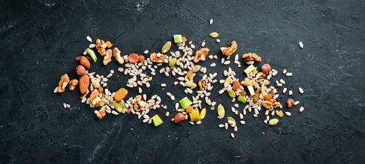 Hazelnut, almonds, raisins, sunflower seeds. On a black background. Top view. Free space for your text.