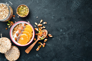 Oatmeal porridge with orange, chia seeds and almonds. Top view. Free space for your text.