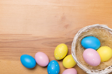 Fototapeta na wymiar Easter eggs in the basket on wooden background