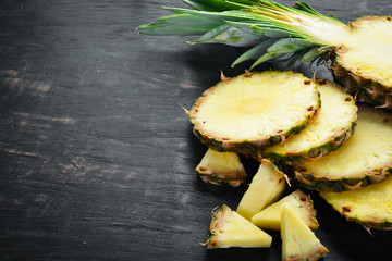 Pineapple. Sliced pineapple on a wooden background. Top view. Free copy space.