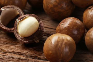 Roasted macadamias on wooden table, selective focus and toned image. Healthy food concept, free space for text.