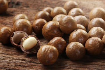 Roasted macadamias on wooden table, selective focus and toned image. Healthy food concept, free space for text.