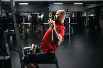 Fototapeta na wymiar Athlete in sportswear on exercise machine in gym