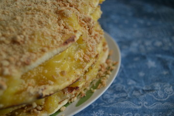 homemade cake withyellow custard.  uneven cake with crumbs on top on the blue background