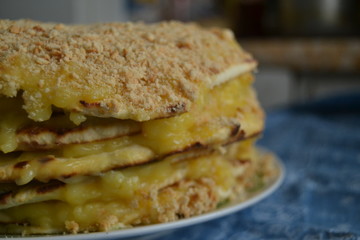 homemade cake withyellow custard.  uneven cake with crumbs on top on the blue background