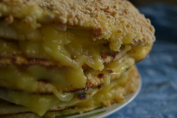 homemade cake withyellow custard.  uneven cake with crumbs on top on the blue background