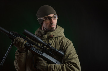 Fototapeta premium The guy in protective clothing and a black mask with a sniper rifle