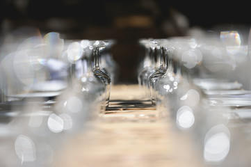 2 filas de copas brillantes puestas boca abajo en banquete con bokeh