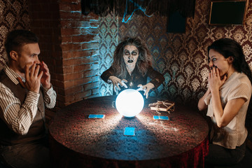 Witch reads scary spell over a crystal ball