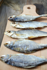 Salty stockfish cod on wooden board with gaarlic and pepper