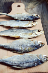 Salty stockfish cod on wooden board with gaarlic and pepper