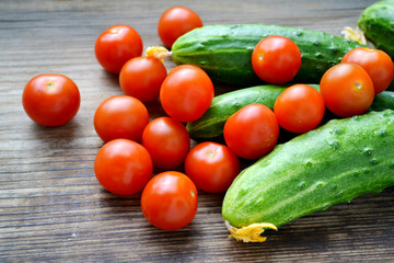 The concept of healthy eating with organic cucumber and cherry tomatoes on wooden table