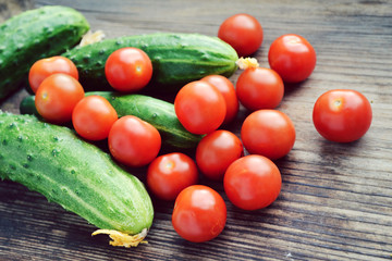 The concept of healthy eating with organic cucumber and cherry tomatoes on wooden table