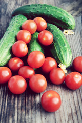 The concept of healthy eating with organic cucumber and cherry tomatoes on wooden table