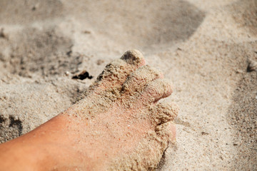Foot of a child in fine sand