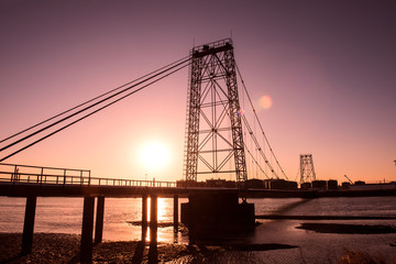 Fototapeta premium Oilfield pipeline bridge in sunset background
