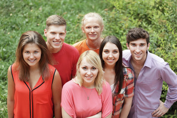 portrait of a group of successful young people on a green lawn