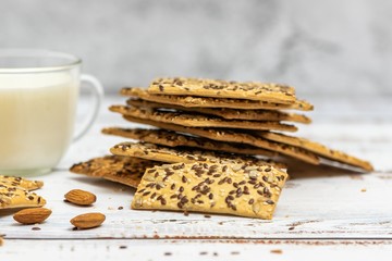 Cup of almond milk and stack of whole grain biscuits on light background. With copy space