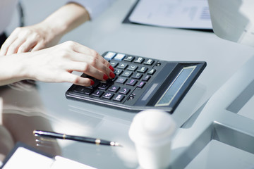 .closeup.business woman using a calculator at the workplace.