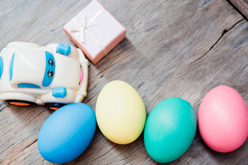 Easter egg and toy car on wooden background,