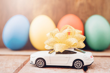 Easter egg and toy car on wooden background,