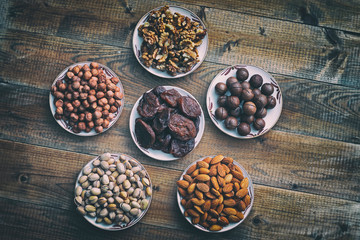 assorted nuts and dried apricots on a wooden background