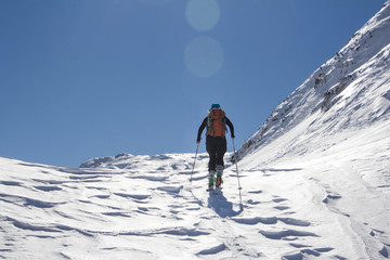 Snow covered mountains and ski mountaineers along sunny trail. Slovenia, Julian Alps, Komna. There are is snowshoeing and ski touring paradise.