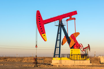 Fototapeta premium Oil pumps are running in the sunset at the oil field. On the Bohai coast of China.