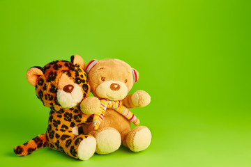 teddy bear; and a toy leopard green background