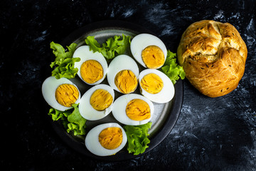 plate with hard-boiled eggs and green leaves of lettuce