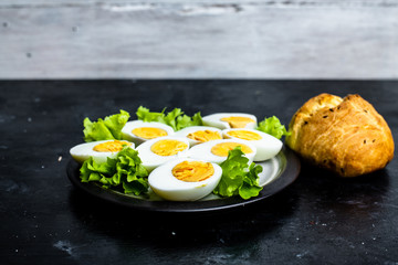 plate with hard-boiled eggs, with the addition of mayonnaise and green leaves of lettuce