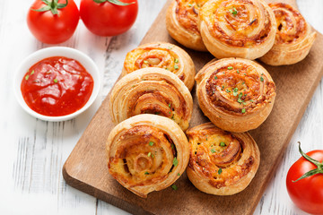 Rolls of puff pastry with bacon and cheese .