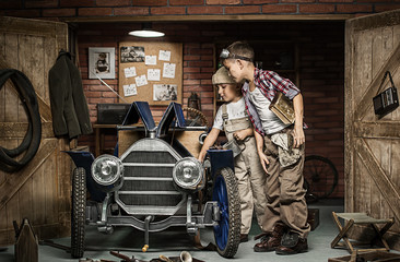 Boys-mechanic with tools in the car in the garage
