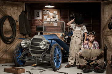 Fototapeta na wymiar Boys-mechanic with tools in the car in the garage