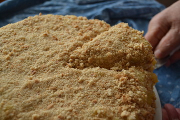 homemade cake withyellow custard.  uneven cake with crumbs on top on the blue background
