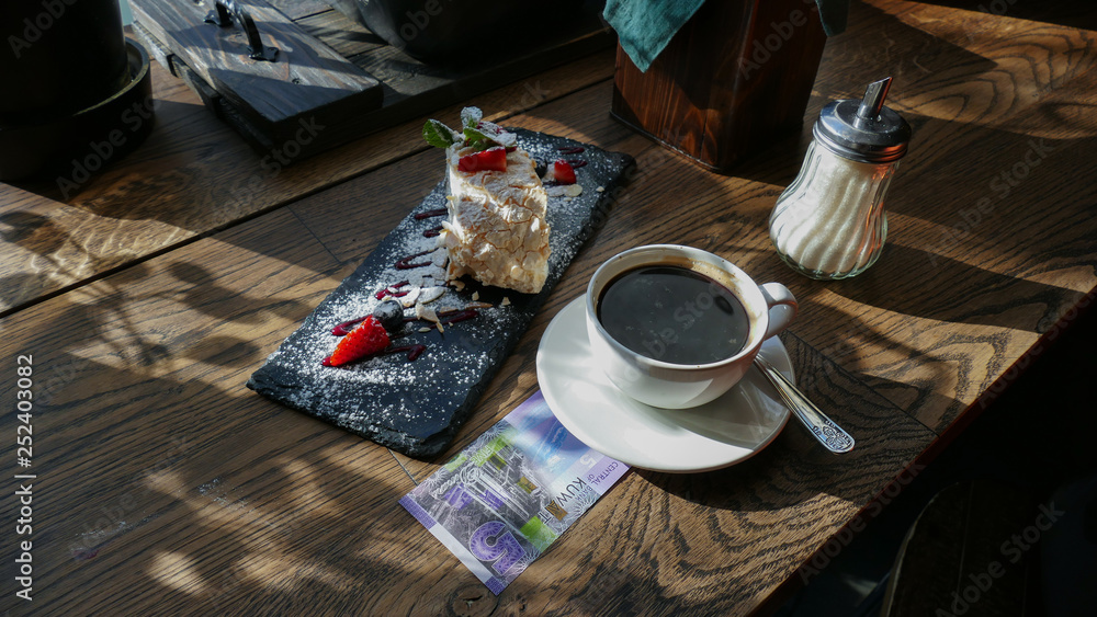 Wall mural kuwaiti banknotes lying under a cup of coffee