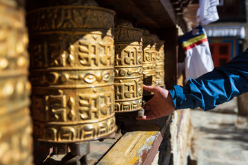 Nepal. Everest trekking. Tibetan prayer wheels in Boudhanath. Hand turns the wheel. On wheels...
