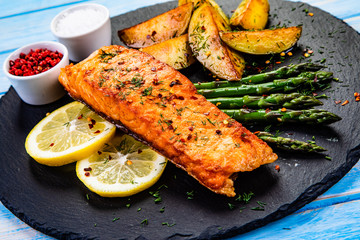 Grilled salmon with baked potatoes, asparagus and vegetable salad